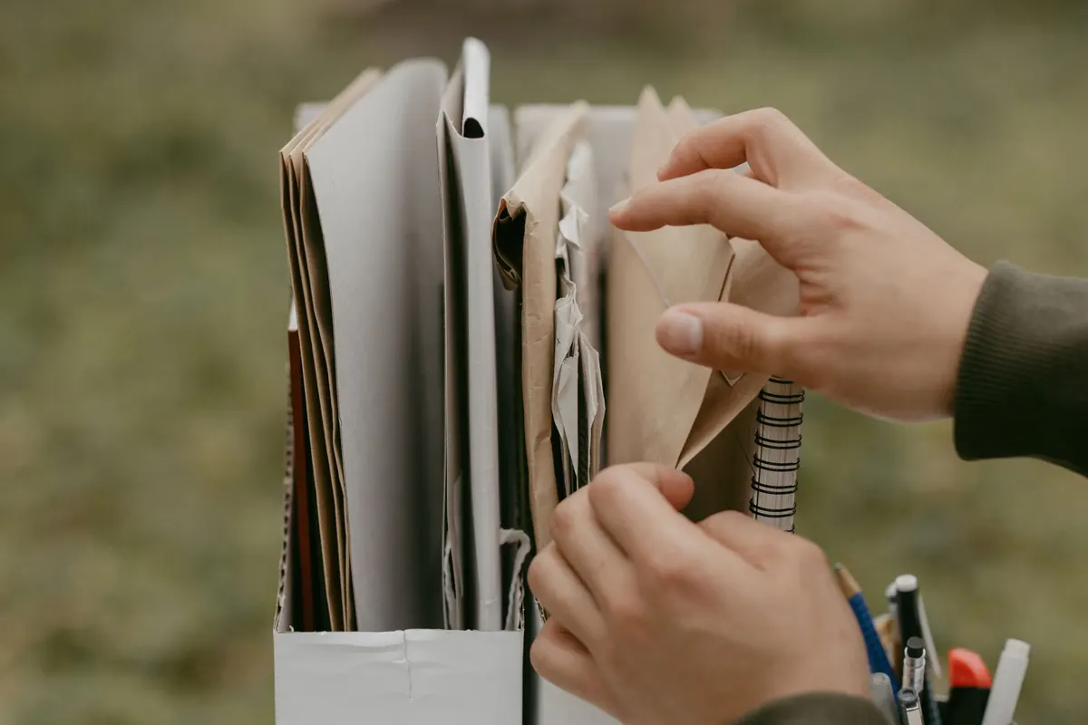Mains triant des documents dans un porte-revues