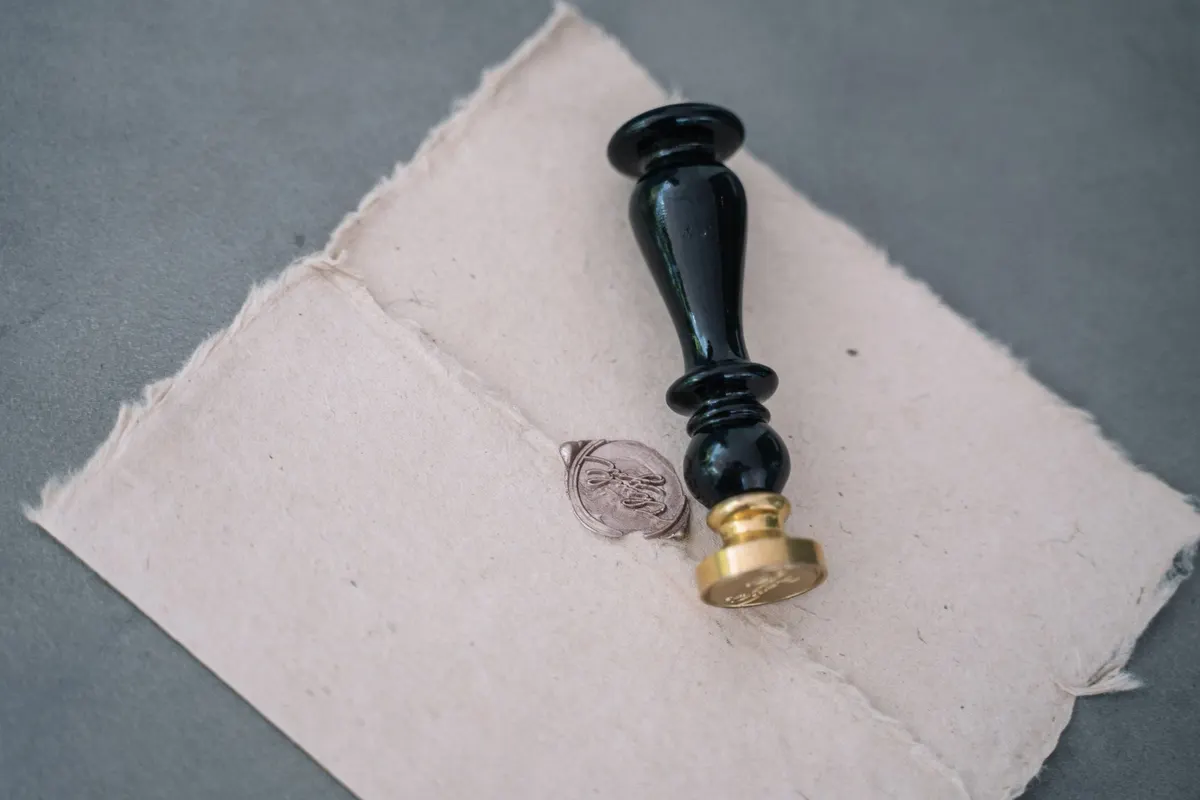 Sceau de cire et son cachet posés sur du papier