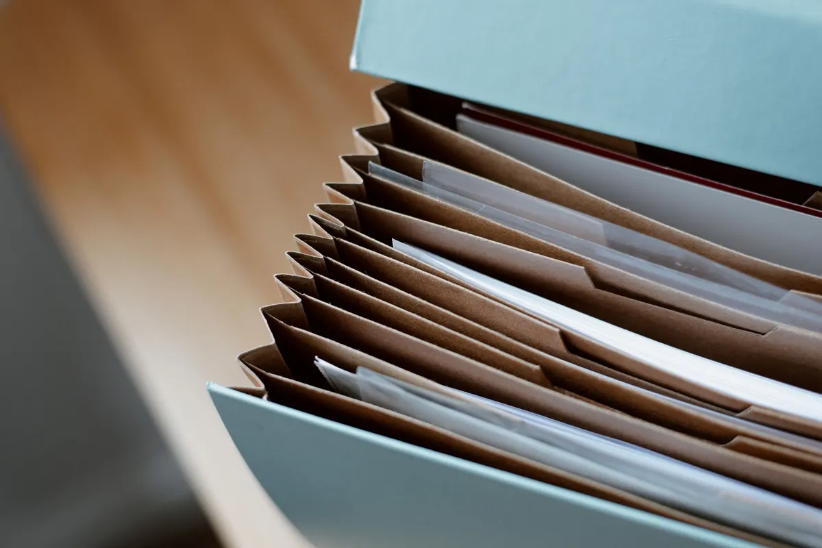 Trieur accordéon rempli de documents sur un bureau
