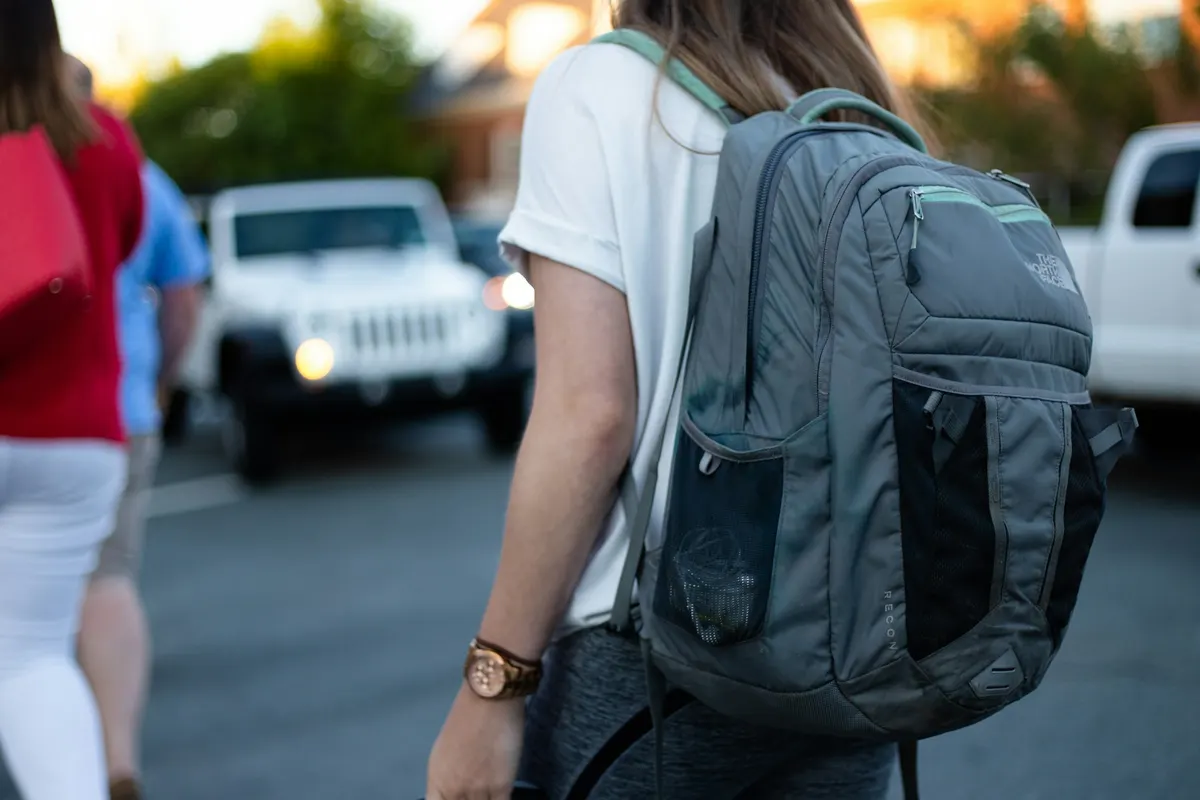 Personne vue de dos portant un sac à dos dans la rue