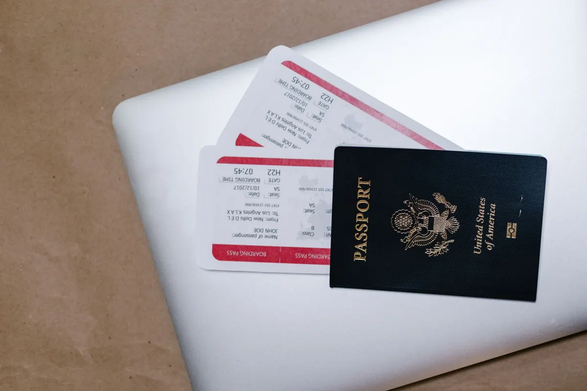 Cartes d'embarquement et passeport posés sur un ordinateur portable