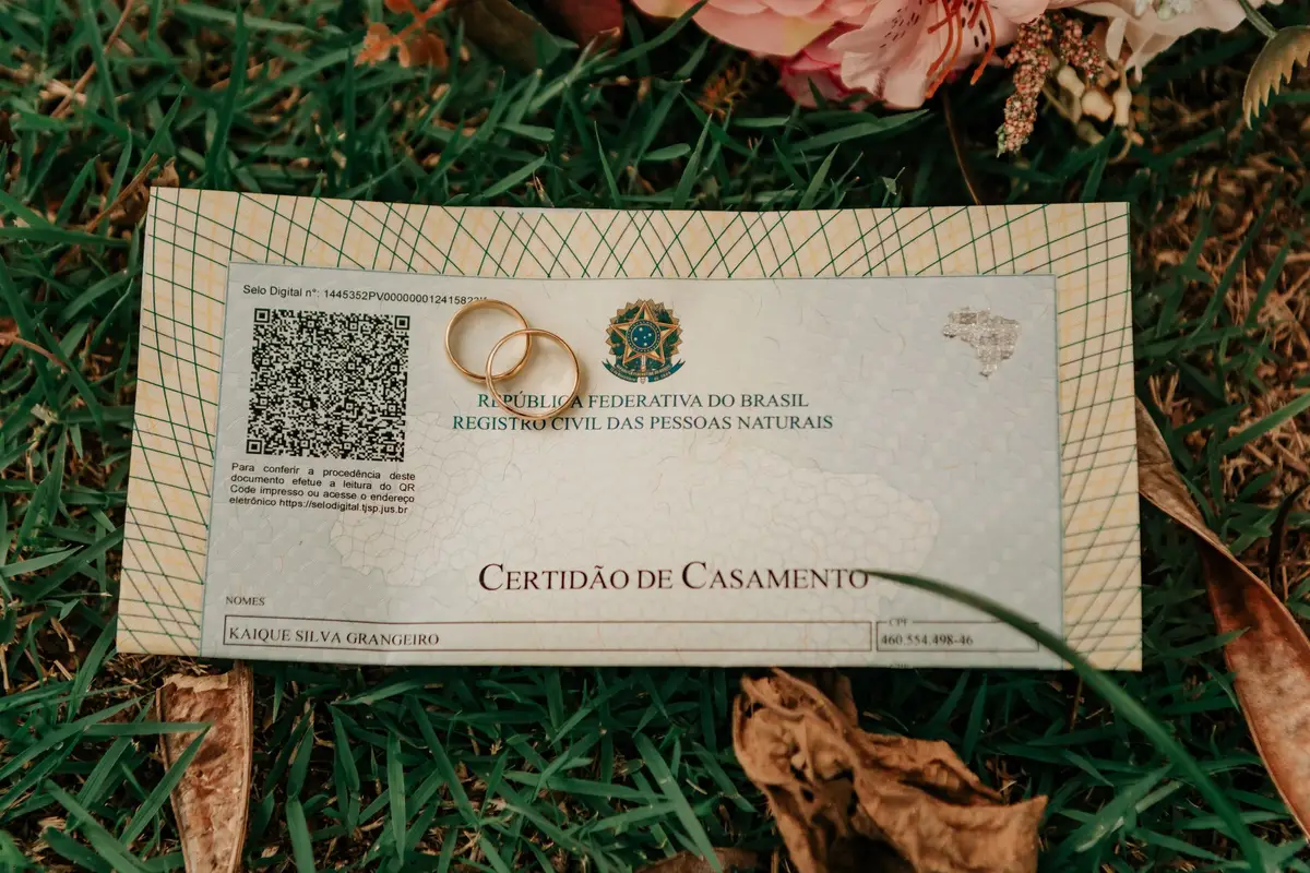 Certificat de mariage posé sur l'herbe avec deux alliances