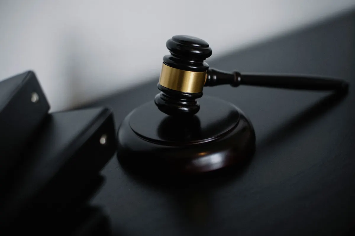 Marteau de juge posé sur un bureau sombre près de classeurs