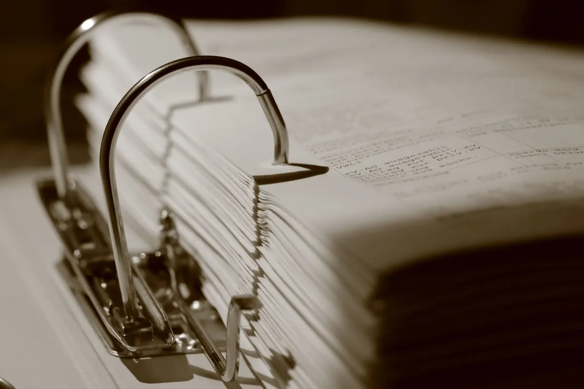 Classeur à anneaux ouvert rempli de documents