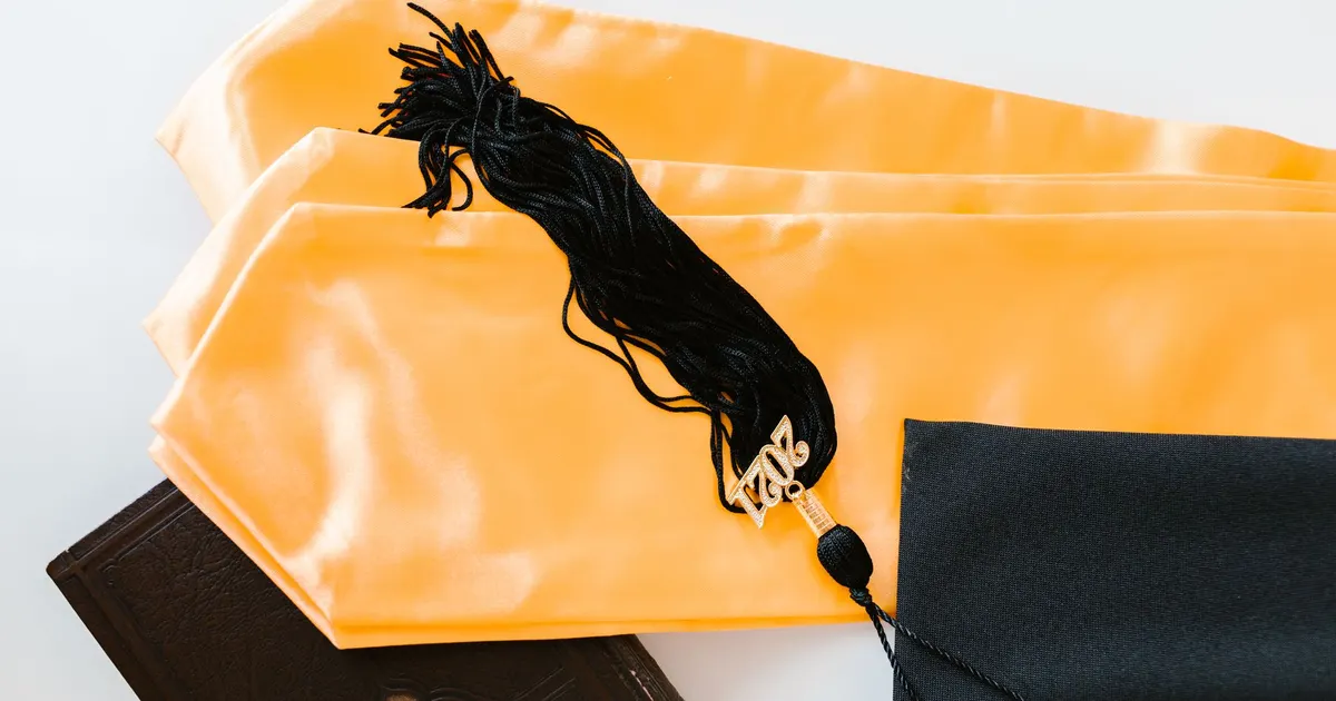Toque de diplômé, gland et livre sur une table