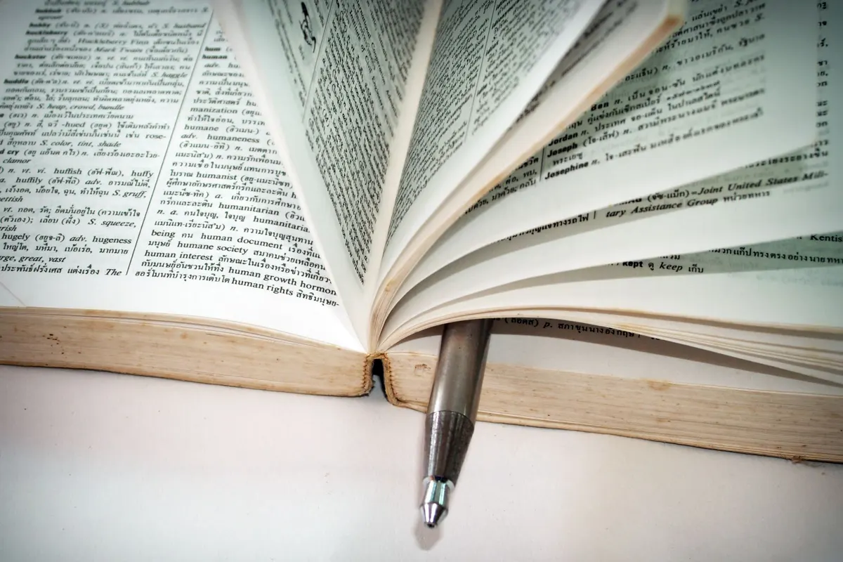 Dictionnaire ouvert avec un stylo glissé entre les pages